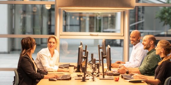 Group of employees sitting around desk