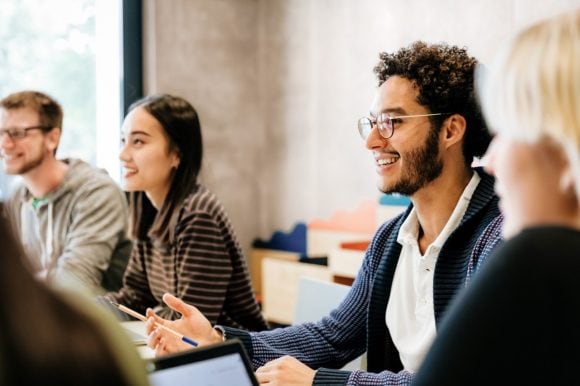 young people smiling and listening in an office