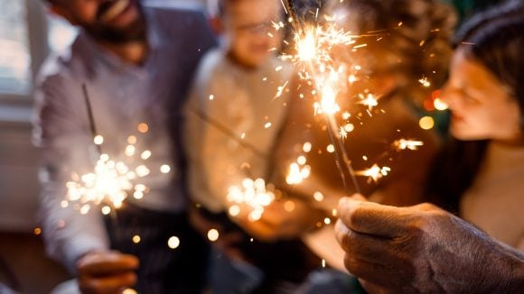 Family celebrating New Year with sparklers