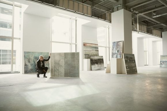 Artist looking at artwork in her art studio