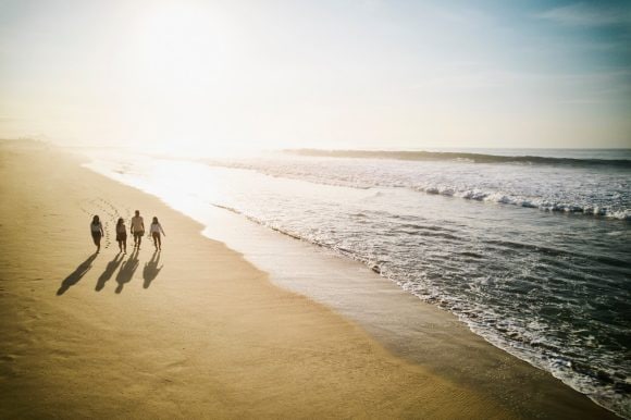 Family walking on the beach during sunset