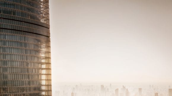 A view of modern glass skyscraper with sunlight reflecting off its surface