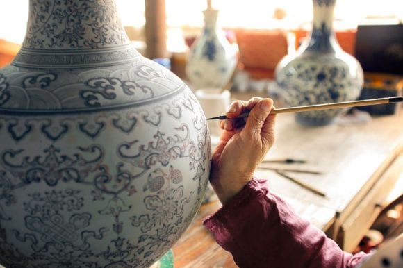 Detail of woman painting clay vase