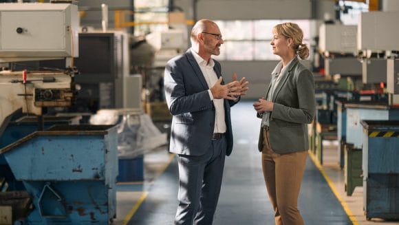 Colleagues discussing in a factory.