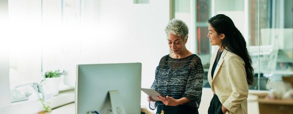 Businesswomen looking at digital tablet in office