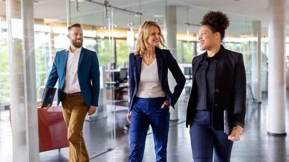 Three young professsionals walking in the office