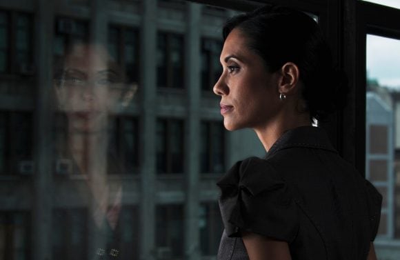 Contemplative woman looking out city window