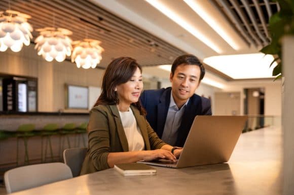 Advisor discussing retirement savings with woman client on laptop