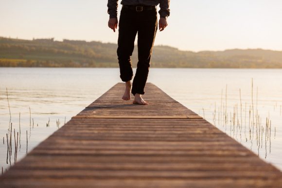 Man walking on pier at lake