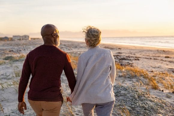 Retired senior couple walking on beach