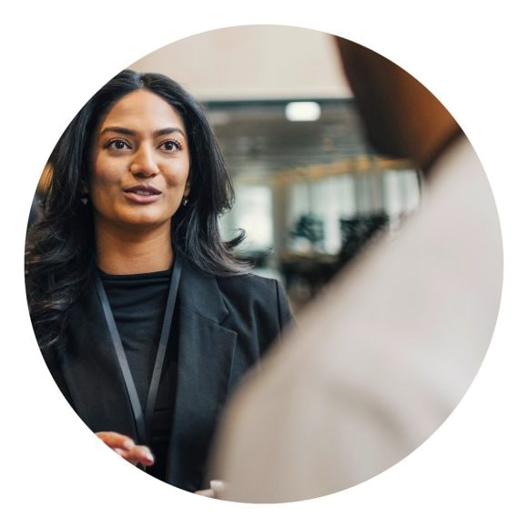 Woman of color speaking with colleagues at conference