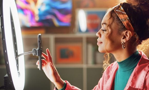 Woman setting up selfie camera, ring light