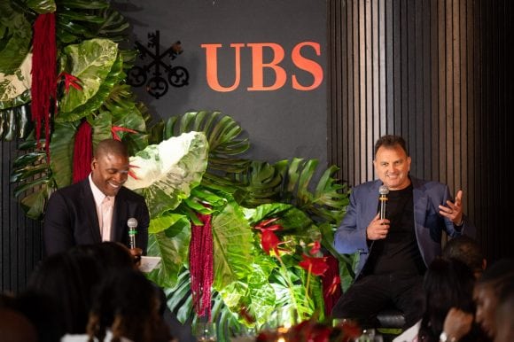 Wale Ogunleye and Drew Rosenhaus on stage chatting at a UBS event