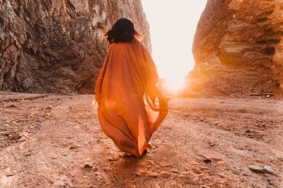 Women walking and looking at a sunset in a desert