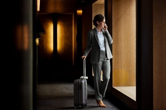 Businesswoman talking on phone in hotel corridor
