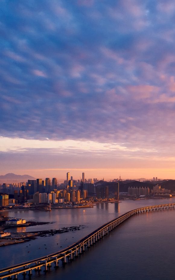 Coastal city with long bridge along its coastline 