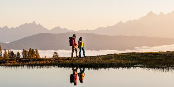 Two people looking over the horizon on a mountain