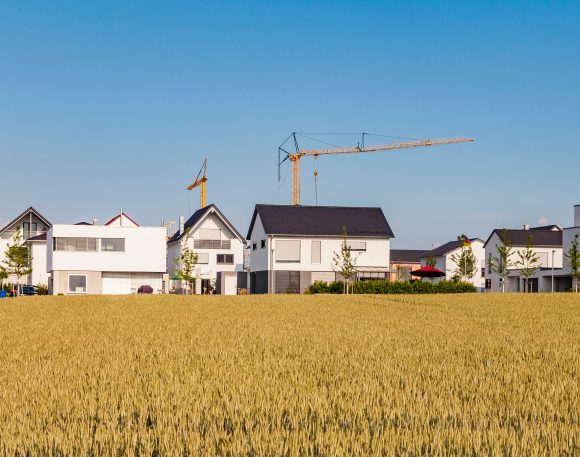 Mature couple sitting in front of an open patio door and chatting.