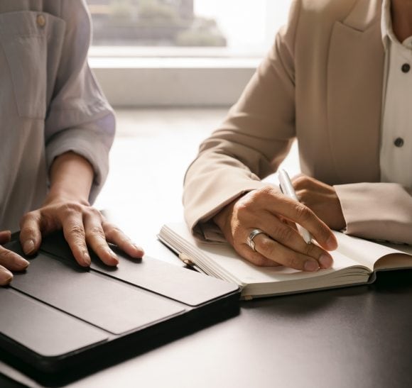 Zwei Menschen sitzen am Tisch und sprechen miteinander.