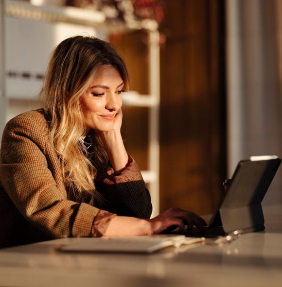 Woman with laptop sitting at the desk.