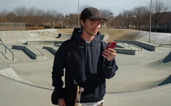 Young man photographed from below against the background of skyscrapers