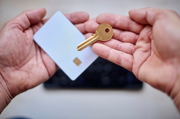 Una carta di pagamento e una chiave nelle mani di una persona adulta.