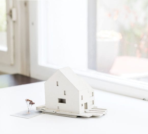 Modellino di casa bianca su un davanzale – simbolo di pianificazione e capitale proprio nell’acquisto di una casa