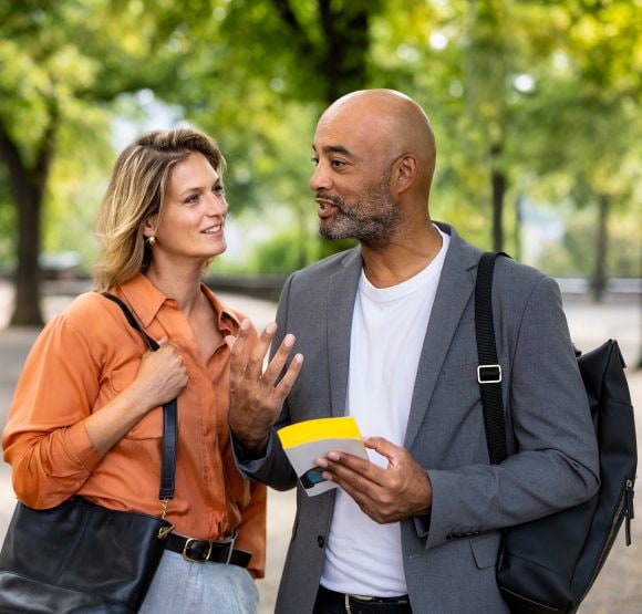 Una coppia in abbigliamento business si intrattiene piacevolmente al parco.