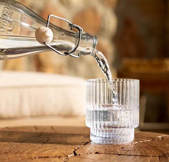 In un bicchiere viene versata dell’acqua da una bottiglia.