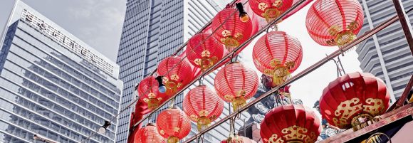 Photo with three skyscraper and a shelve with hanging red chinese lampion