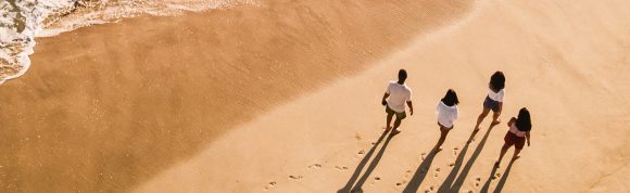 Une famille se promène sur la plage.