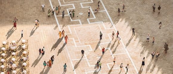 Aerial view of people walking across a square in Venice.