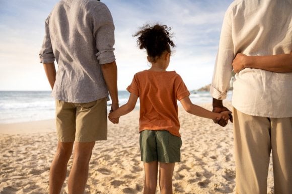 Girl with father and grandfather on beach