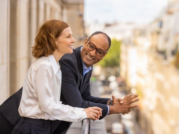 A woman and a man in conversation on a balcony, Paris