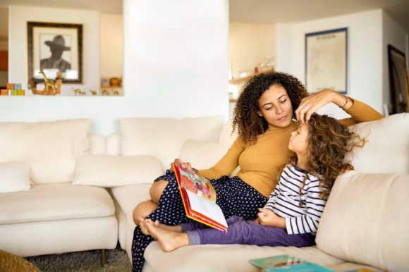 Lady and a girl sitting on a couch