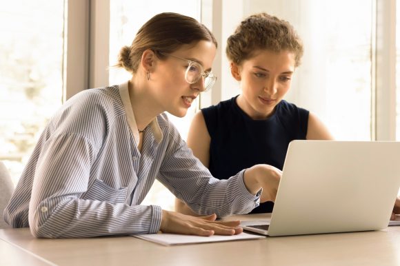 Zwei junge Frauen arbeiten am Laptop