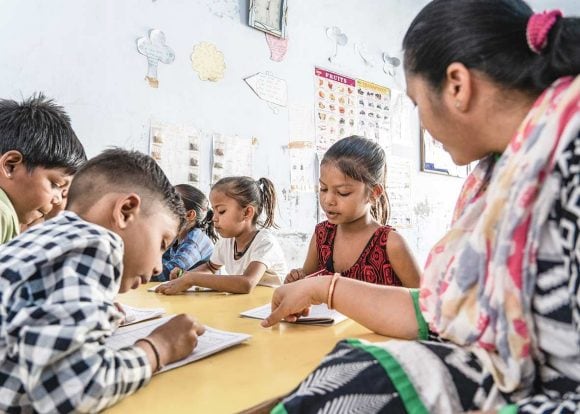 Eine Gruppe Schulkinder wird instruiert von Lehrerin.