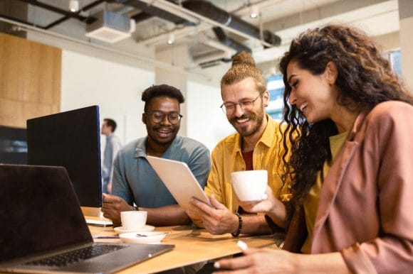 Drei Kolleginnen und Kollegen suchen gemeinsam nach Lösungen.