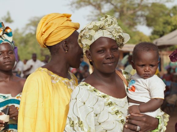A smiling mother holding a young child