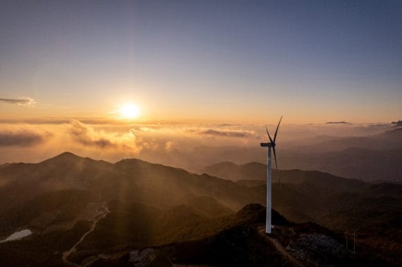 Wind turbine on a mountain ridge at sunset
