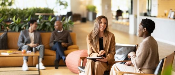 Two women having conversation in office space