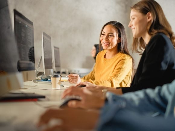 Two friends looking at desktop