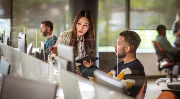 Two colleagues discussing in front of computer