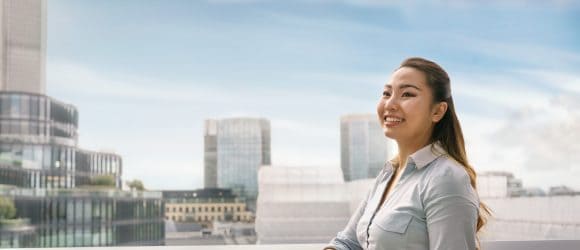 Female summer intern standing in front of London cityscape