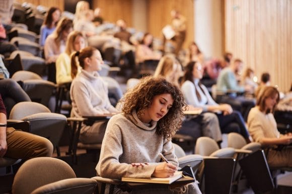 woman in university classroom writing an exam