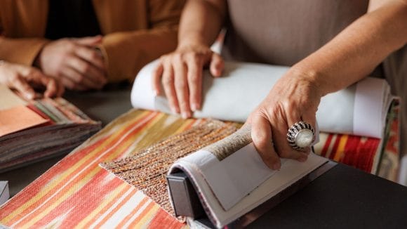 People looking through stacks of fabric samples