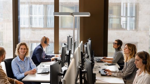Office with people using computers facing eachother
