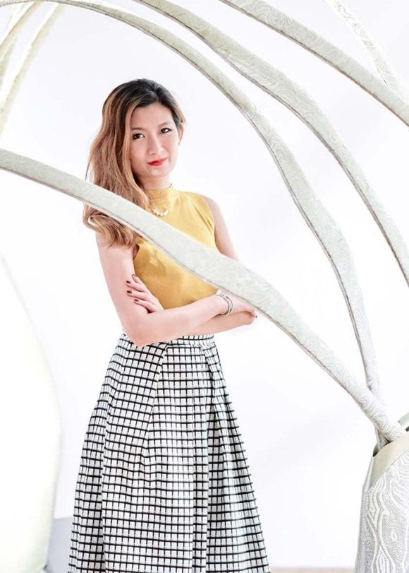 woman standing next to a piece of art