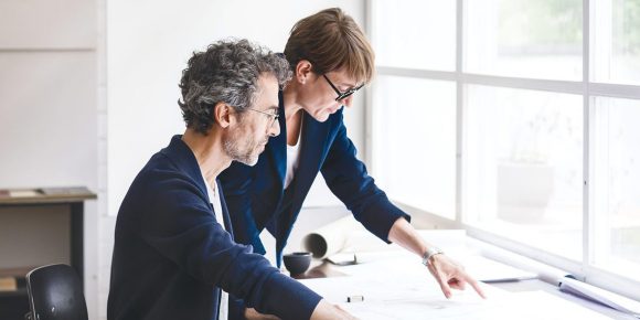 Man and woman looking at sheet of paper.