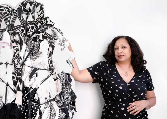 woman standing next to a piece of art